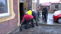 Einsatzkräfte und Anwohner am Tag danach vor ihrem Haus.