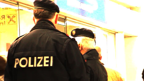 Zwei Polizisten* machen beim Ticket-Schalter von Brüssel Airline den Aktivist_innen Stress