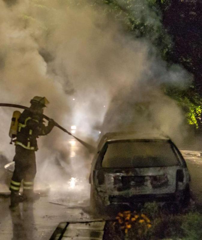 Ein Feuerwehrmann löscht den Wagen in der Straße Heukoppel