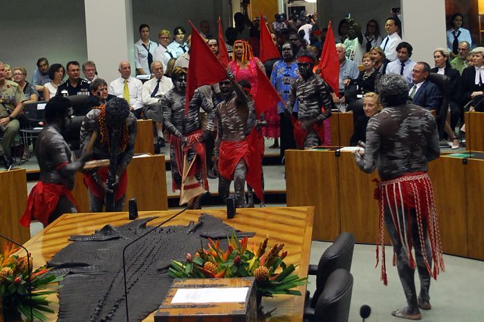 An Aboriginal member ceremoniously led to her place in parliament.