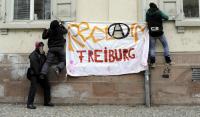 Schattenparker bringen am Gerichtsgebäude ein Protesttransparent an