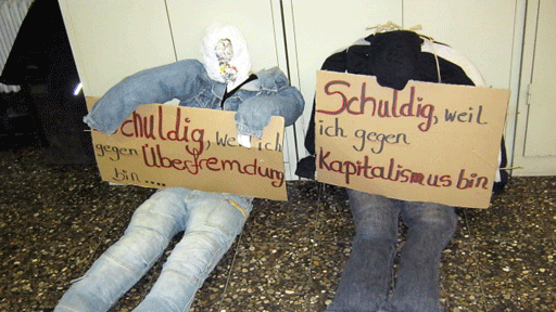 Zwei Puppen mit Pappschildern: Die Puppen wurden von der Polizei beschlagnahmt